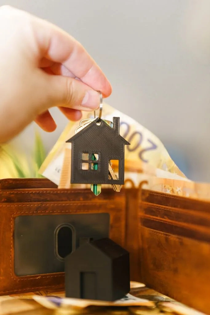 A person putting a house key into a wallet